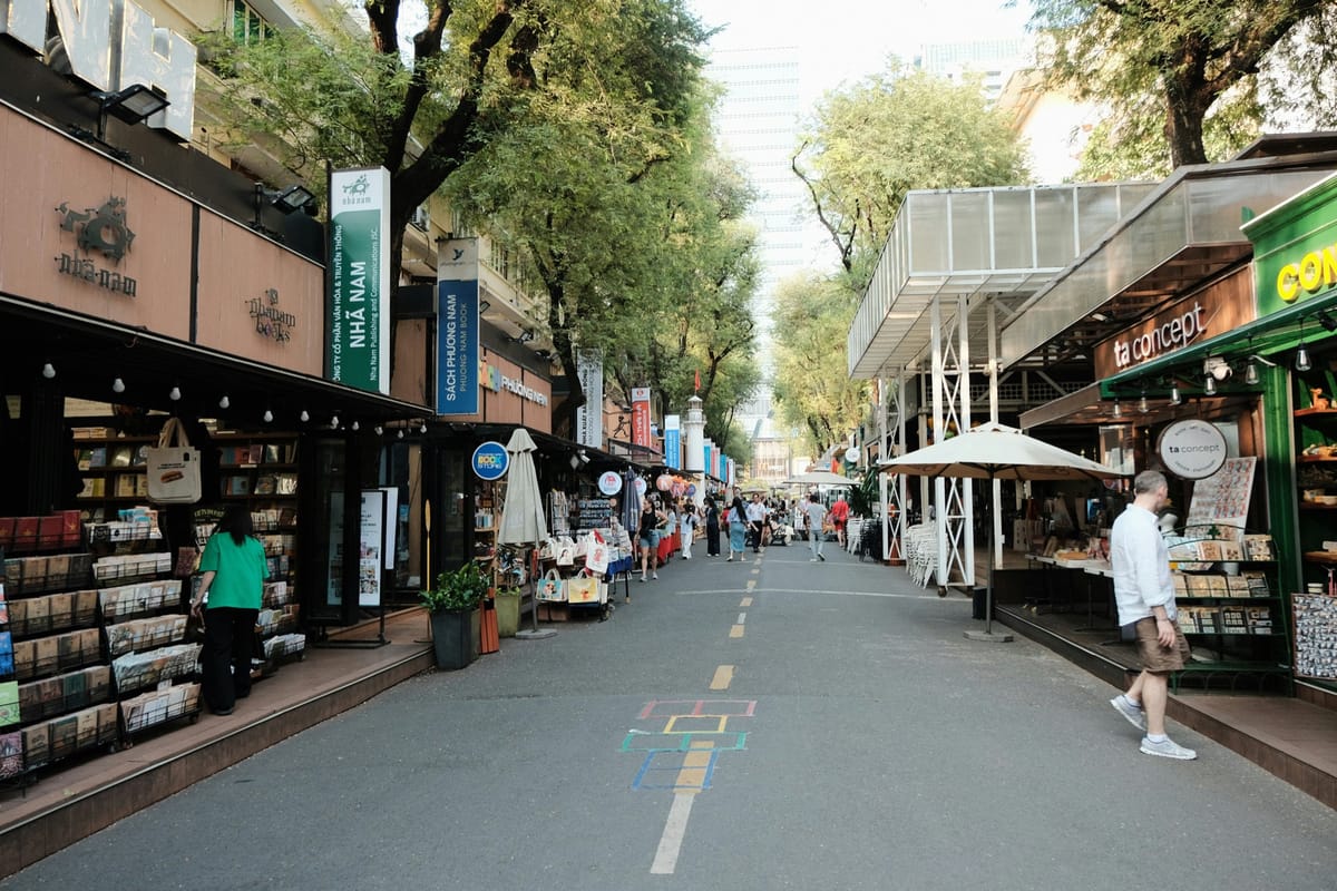 胡志明市阮文平書街的綠蔭步道，兩旁書攤與看書的人