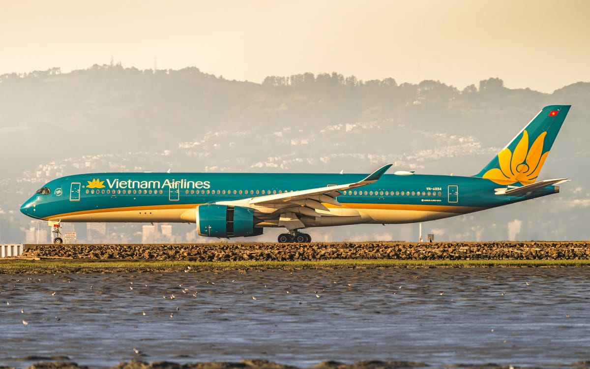越南航空 A350 客機在金黃色晨光中沿水岸滑行