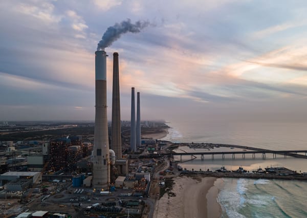 黃昏時分的沿海燃煤電廠空拍，高聳煙囪冒著煙
